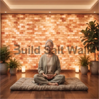 Senior Woman Meditating in Front of Warm Illuminated Himalayan Salt Brick Feature Wall